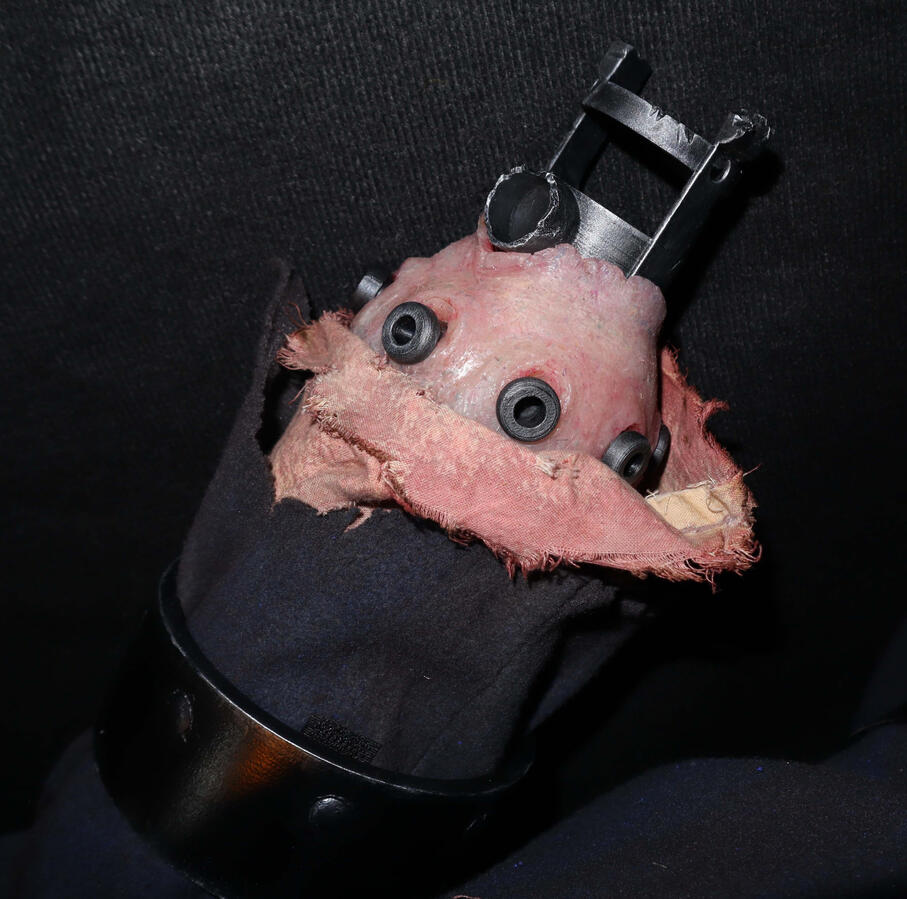 Close-up of left arm stump with broken joint piece and bolt pieces