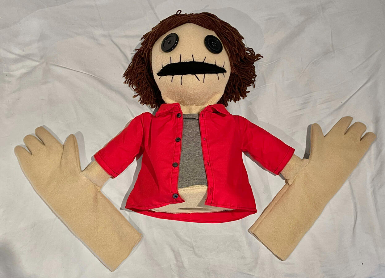 Final Puppet dressed in red shirt with live-hands attached